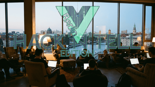 People sitting in a barely lit room with laptops, in front of a large window showing the Berlin skyline with the Vuejs Berlin logo.